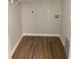 Empty laundry room with neutral walls, wood floors, and a storage shelf at 2467 Shady Grove Rd, Carrollton, GA 30116