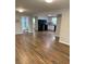 Open-concept living space with views of the kitchen, modern appliances, and stylish wood flooring at 2467 Shady Grove Rd, Carrollton, GA 30116