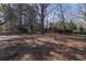 Expansive backyard featuring mature trees and a cozy swing set for outdoor enjoyment at 341 Little John Nw Dr, Lilburn, GA 30047