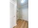 Well-lit laundry room with white cabinets, shelving, and wooden vinyl floors at 341 Little John Nw Dr, Lilburn, GA 30047