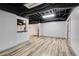 Spacious finished basement with wood-look flooring, gray walls, and a black painted ceiling at 243 Yorkshire Ln, Villa Rica, GA 30180