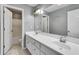 Bathroom featuring double sinks, large mirror, tile floors, and a separate shower/toilet area at 243 Yorkshire Ln, Villa Rica, GA 30180