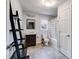 Bright bathroom with gray tile floors, a dark wood vanity, and a decorative shelving ladder for storage at 243 Yorkshire Ln, Villa Rica, GA 30180