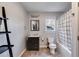 Bathroom with a dark wood vanity, tile floors, shelving, and a shower/tub combo with curtain at 243 Yorkshire Ln, Villa Rica, GA 30180