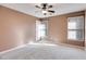 A light-filled bedroom with neutral walls, carpeted floors, two windows, and a ceiling fan at 243 Yorkshire Ln, Villa Rica, GA 30180