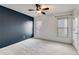 Bedroom with a dark blue accent wall, carpeted floors, two windows, and a ceiling fan at 243 Yorkshire Ln, Villa Rica, GA 30180