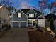 Traditional home at dusk showcasing gray siding, stone detail, manicured landscaping, and a two-car garage at 243 Yorkshire Ln, Villa Rica, GA 30180