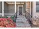 Welcoming front porch with stone steps, metal railings, and landscaped flowerbeds at 243 Yorkshire Ln, Villa Rica, GA 30180