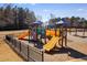 Community playground with slides and climbing structures surrounded by a black metal fence at 243 Yorkshire Ln, Villa Rica, GA 30180