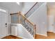 Elegant staircase with hardwood floors, carpeted steps, and wrought iron spindles, adding a touch of sophistication at 243 Yorkshire Ln, Villa Rica, GA 30180