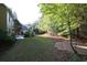 Large backyard with mature trees and a small deck area on the house at 6131 Windflower Dr, Powder Springs, GA 30127