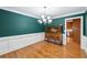 Dining room features dark teal wall, wainscotting, hardwood floors and cabinet at 289 Barn Rd, Canton, GA 30115
