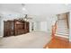 Bright living area featuring custom built-ins, plush carpeting, and an adjacent staircase at 289 Barn Rd, Canton, GA 30115