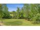 A spacious yard with mature trees sits underneath a clear blue sky at 289 Barn Rd, Canton, GA 30115