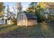 A backyard storage shed with a white trim and a black shingle roof at 1526 N Cherokee N Rd, Social Circle, GA 30025