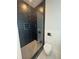 Bathroom featuring a sleek glass-enclosed shower with dark tile and modern fixtures, alongside a contemporary toilet at 2719 Winding Ne Ln, Brookhaven, GA 30319