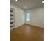 A compact bedroom with hardwood flooring, a modern window with a nature view, and a door with decorative panels at 2719 Winding Ne Ln, Brookhaven, GA 30319