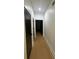 Well-lit hallway with hardwood flooring and white trim with a black door, leads to the home's living spaces at 2719 Winding Ne Ln, Brookhaven, GA 30319