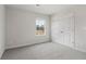 Bright bedroom featuring grey carpet, window, and double doors at 3913 Brushy St, Powder Springs, GA 30127