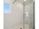 Modern shower featuring floor-to-ceiling marble-like tile, glass door and window at 4835 Marjorie Dr, Cumming, GA 30041