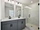 This bathroom includes a glass shower, vanity with double sinks, and modern finishes at 5130 Kongoni Ct, Cumming, GA 30041