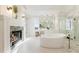 Luxurious bathroom with a soaking tub, fireplace, and marble accents at 8380 Sentinae Chase Dr, Roswell, GA 30076