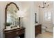 Stylish half bath with a dark wood vanity, vintage mirror, and chic light fixture at 8380 Sentinae Chase Dr, Roswell, GA 30076