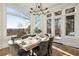 Dining room with a modern chandelier, hardwood flooring, and a wall of windows providing beautiful wooded views at 8380 Sentinae Chase Dr, Roswell, GA 30076