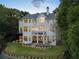 Rear exterior view of a stately home with a manicured lawn and multiple balconies at 8380 Sentinae Chase Dr, Roswell, GA 30076