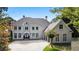 Stunning two-story home with a grand entrance, a circular driveway, and manicured landscaping at 8380 Sentinae Chase Dr, Roswell, GA 30076