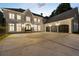 Elegant brick home featuring a circular driveway, arched windows, and a three-car garage at 8380 Sentinae Chase Dr, Roswell, GA 30076