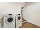 Modern laundry room featuring sleek, high-end appliances and wood look tile flooring at 8380 Sentinae Chase Dr, Roswell, GA 30076