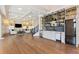 Expansive living room featuring custom bar area, hardwood floors, and ample built-in storage at 8380 Sentinae Chase Dr, Roswell, GA 30076
