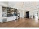 Stylish living room with a custom bar, open layout, hardwood floors, and modern lighting at 8380 Sentinae Chase Dr, Roswell, GA 30076