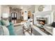 Well-lit living room with hardwood floors, a fireplace, a dark front door, and views of the foyer at 8380 Sentinae Chase Dr, Roswell, GA 30076