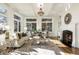 Bright living room with coffered ceilings, fireplace, hardwood floors, and large windows showcasing outside views at 8380 Sentinae Chase Dr, Roswell, GA 30076