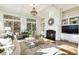 Bright living room featuring a fireplace, built-in shelves, hardwood floors, and multiple windows for ample natural light at 8380 Sentinae Chase Dr, Roswell, GA 30076