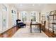 Bright office space with large windows, hardwood floors, modern shelving and a comfortable reading area at 8380 Sentinae Chase Dr, Roswell, GA 30076