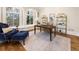 Cozy office with natural light, hardwood floors, designer shelving, and comfortable blue armchairs at 8380 Sentinae Chase Dr, Roswell, GA 30076