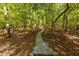 Serene walking path winding through a lush, wooded area, providing a tranquil escape at 8380 Sentinae Chase Dr, Roswell, GA 30076