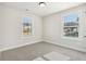 Well-lit bedroom with neutral carpeting and two windows at 4755 Marjorie Dr, Cumming, GA 30041