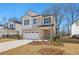 Two-story house with light-colored brick and a two-car garage at 4755 Marjorie Dr, Cumming, GA 30041