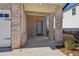 Covered front porch with brick columns and a gray door at 4755 Marjorie Dr, Cumming, GA 30041