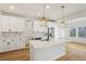 Open concept kitchen with white cabinets, mosaic backsplash, and stainless steel appliances at 4755 Marjorie Dr, Cumming, GA 30041