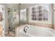 Bathroom with soaking tub, walk-in shower, and granite accents at 5065 Winship Ct, Alpharetta, GA 30009