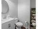 Powder room featuring a modern vanity, decorative mirror, and stylish shelving at 1250 Olympic Dr, Oxford, GA 30054