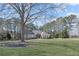 Landscaped front yard with a large tree shading a brick home with wood-trimmed gable at 1250 Olympic Dr, Oxford, GA 30054