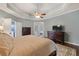 Spacious main bedroom with tray ceiling, wooden furniture, and large rug on hardwood floor at 1250 Olympic Dr, Oxford, GA 30054