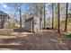 New outdoor shed with a brown exterior and gray roof surrounded by mature trees at 1250 Olympic Dr, Oxford, GA 30054