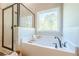 Bright bathroom showcasing a tub with a shower and a large window at 30 Pinewood Dr, Covington, GA 30014